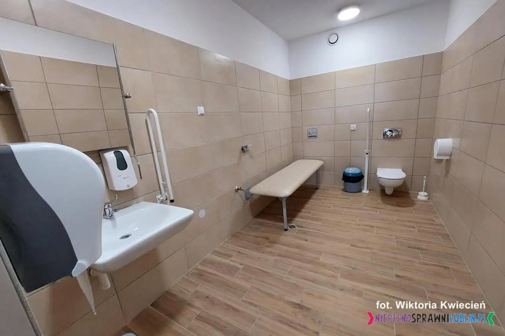 Toaleta z wyposażeniem dla osób z niepełnosprawnością oraz wstawioną leżanką